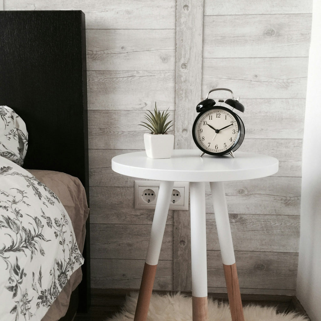 Rowan round side table styled beside a bed