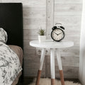 Rowan round side table styled beside a bed