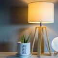 Aster tripod table lamp glowing on a side table