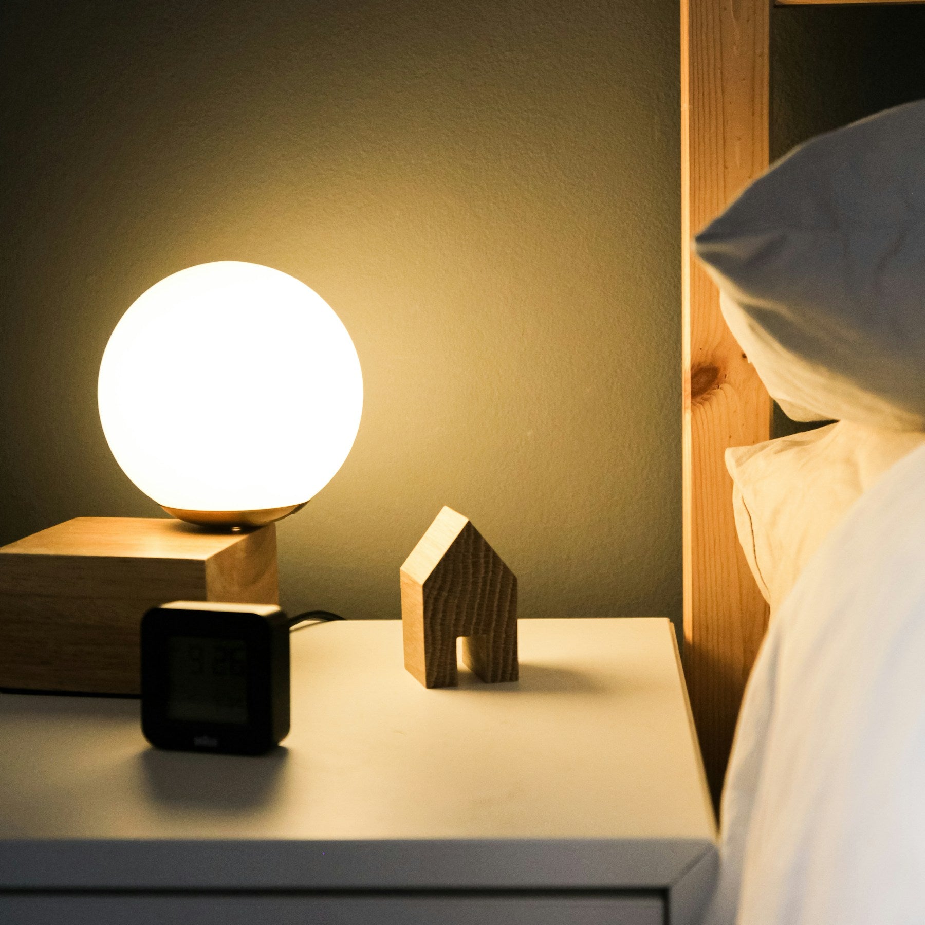 Compact globe table lamp styled beside a bed