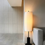 Tall Vela linen floor lamp glowing in a corner